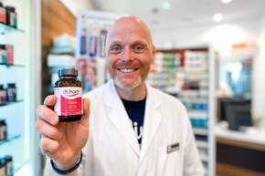 Pharmazeut hält ein Dr. Hartl Produkt in der Hand