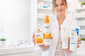 Apothekenmitarbeiterin präsentiert verschiedene Sonnenschutzprodukte mit hohem Lichtschutzfaktor für empfindliche Haut und täglichen UV-Schutz.