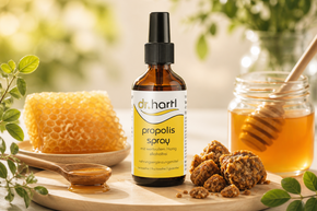 Dr. Hartl Propolis Spray mit Honig, umgeben von Honigwabe, Propolisstücken und Natur-Elementen